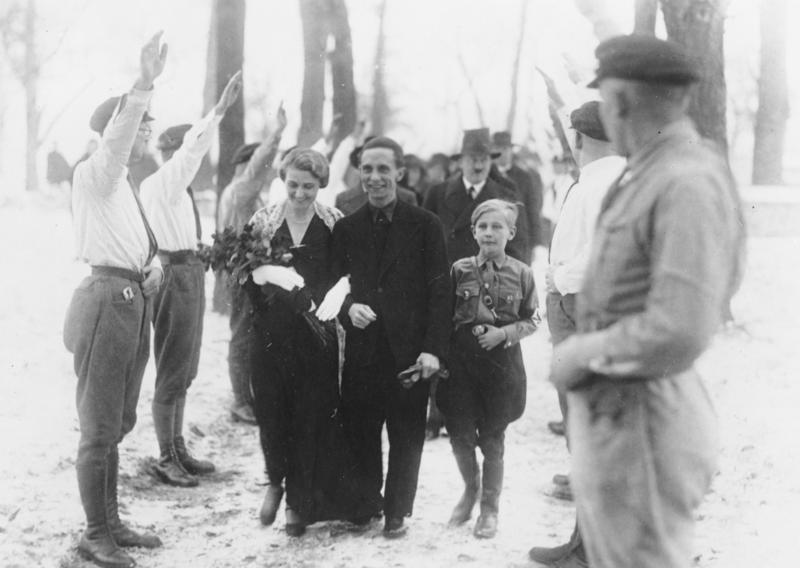 חתונתם של מגדה ויוזף גבלס. מאחוריהם, אדולף היטלר. דצמבר 1931 (Bundesarchiv, Bild 183-R32860 Creative Commons)