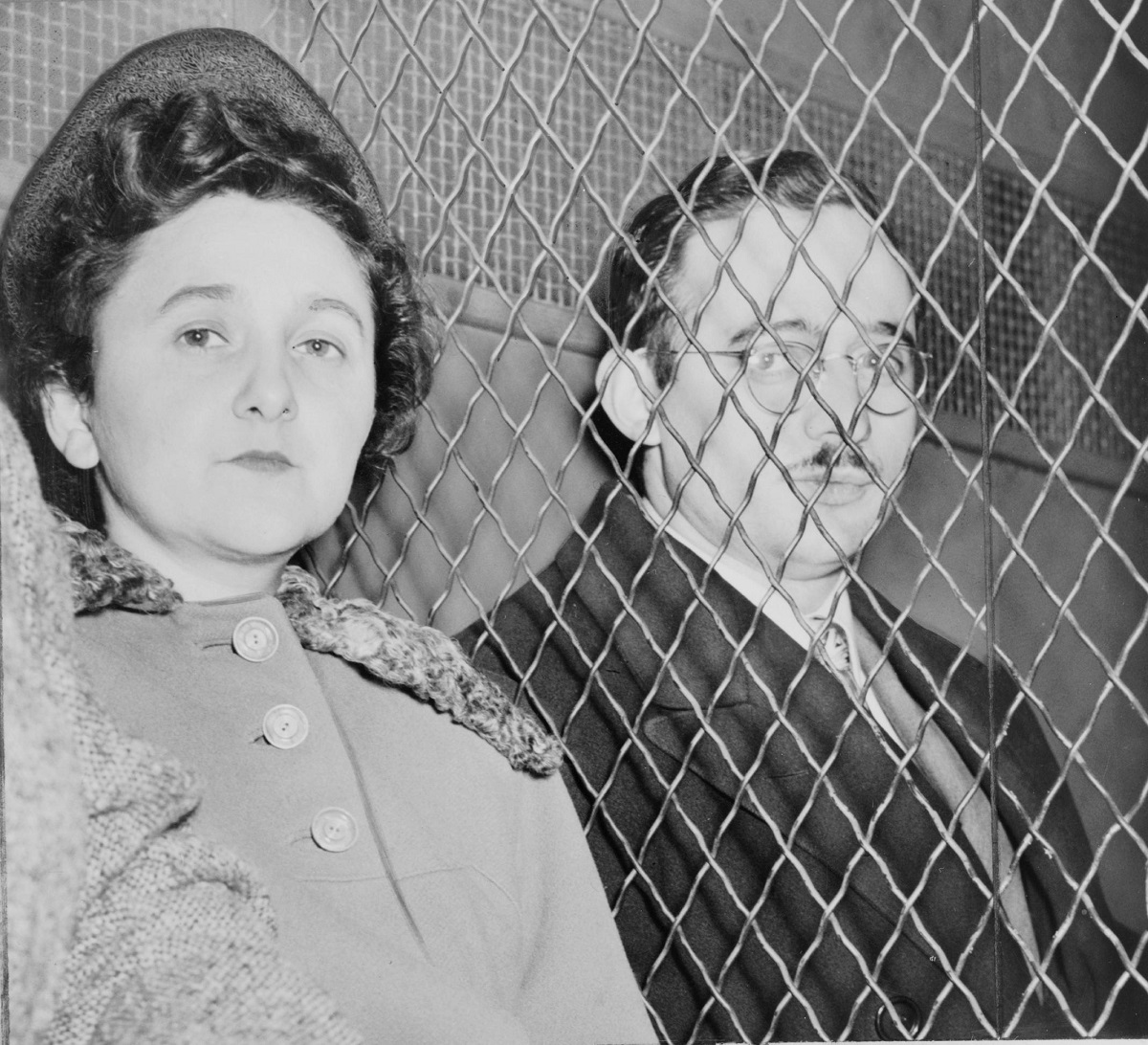 Julius and Ethel Rosenberg, separated by heavy wire screen as they leave U.S. Court House after being found guilty by jury, 1951