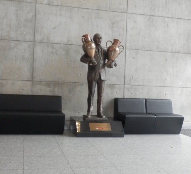 פסל בדמות בלה גוטמן מחזיק בשני גביעי אירופה לאלופות, מחוץ לאצטדיון "האור", מגרשה הביתי של בנפיקה ליסבון (Creative Commons Attribution- Threeohsix)