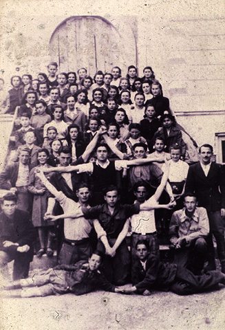 חברי תנועת נוער ציונית מצטלמים כשהם יוצרים בידיהם צורת מגן דוד, רומניה, 1945 (בית התפוצות, המרכז לתיעוד חזותי ע"ש אוסטר, ארכיון תנועת העבודה ע"ש לבון)