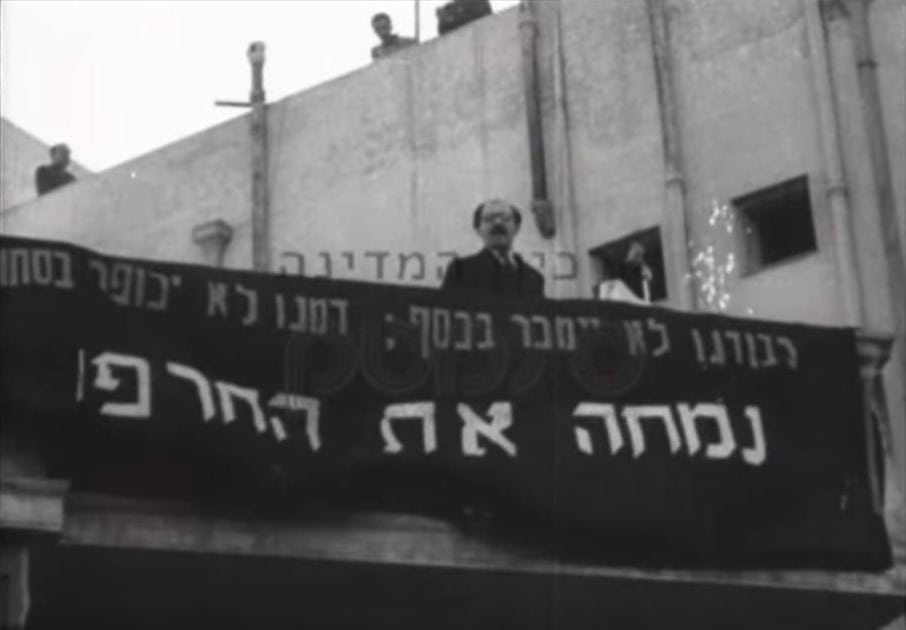 מנחם בגין נואם את נאום השילומים בכיכר ציון, ירושלים, ינואר 1952 (צילום מסך: ארכיון המדינה)