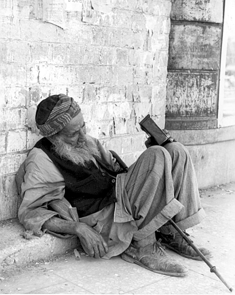 Old beggar with a charity box sitting in the street, Jerusalem 1950s. Photo: Herbert Sonnenfeld. Beit Hatfutsot, the Oster Visual Documentation Center, Sonnenfeld collection