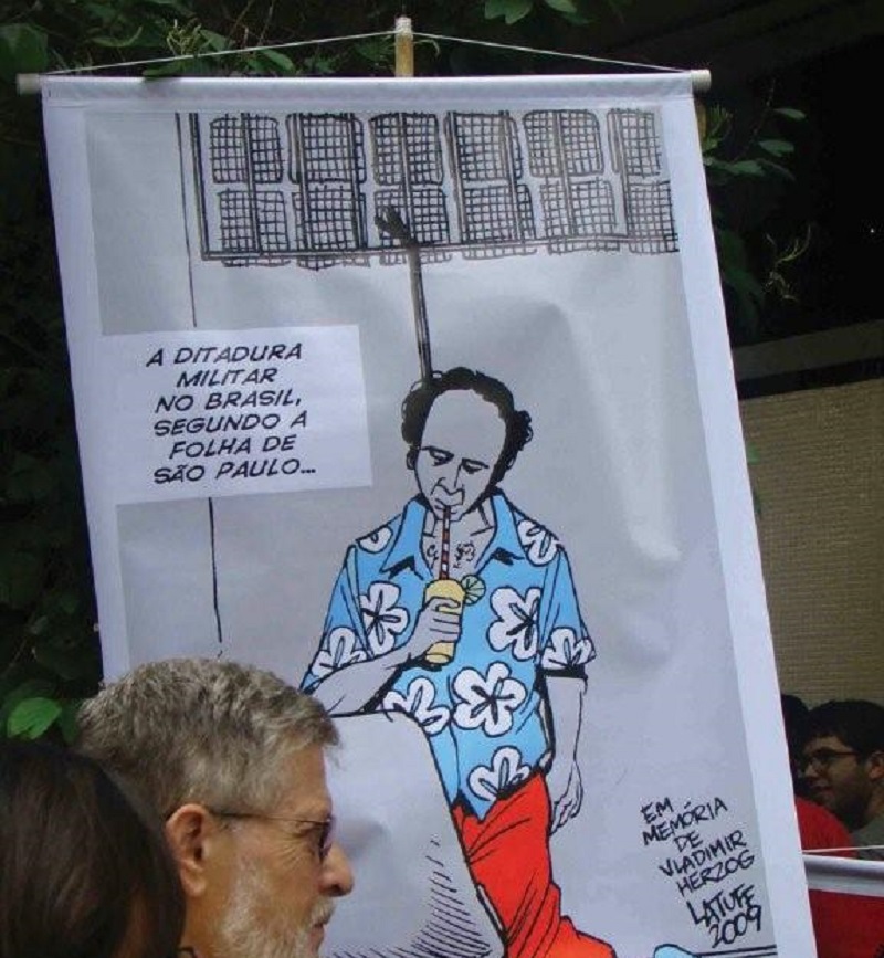 2009 protest in Brazil. The poster, ironically depicting Vladimir Herzog, the journalist murdered in 1975, in casual attire, reads with the sarcastic caption: "The military dictatorship in Brazil, according to Folha de São Paulo (revista Forum. Wikipedia)