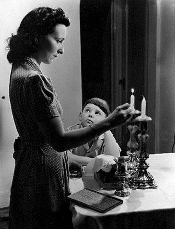 אם בהדלקת נרות שבת, ניו יורק, ארה"ב שנות 1950. צילום: הרברט זוננפלד. בית התפוצות, המרכז לתיעוד חזותי ע"ש אוסטר, אוסף זוננפלד