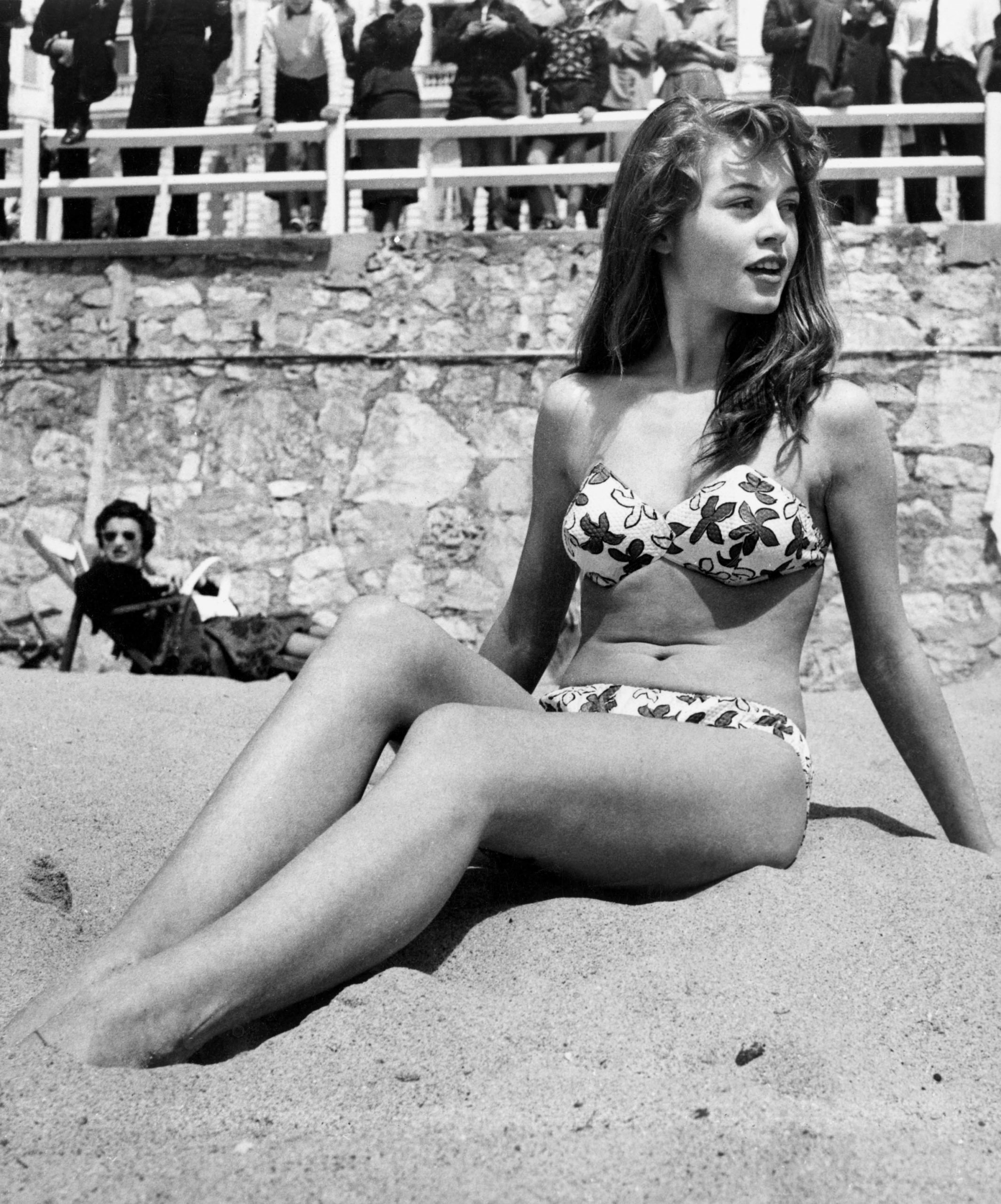 French actress Brigitte Bardot sitting on the beach during the Cannes Film Festival, 1953. (Photo by Patrick Morin/ Wikipedia)