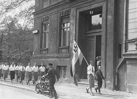 Students organized by the Nazi party parade in front of the building of the Institute for Sexual Research in Berlin prior to pillaging it on May 6, 1933 (United States Holocaust Memorial Museum, wikipedia)