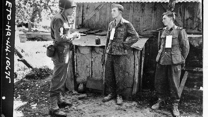 Martin Selling questions German prisoners near the front in France, 1944. (U.S. Army Signal Corps)