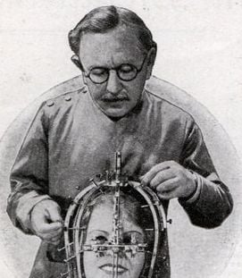 Max Factor in 1935, demonstrating his beauty micrometer device (Modern Mechanix magazine, Wikipedia)