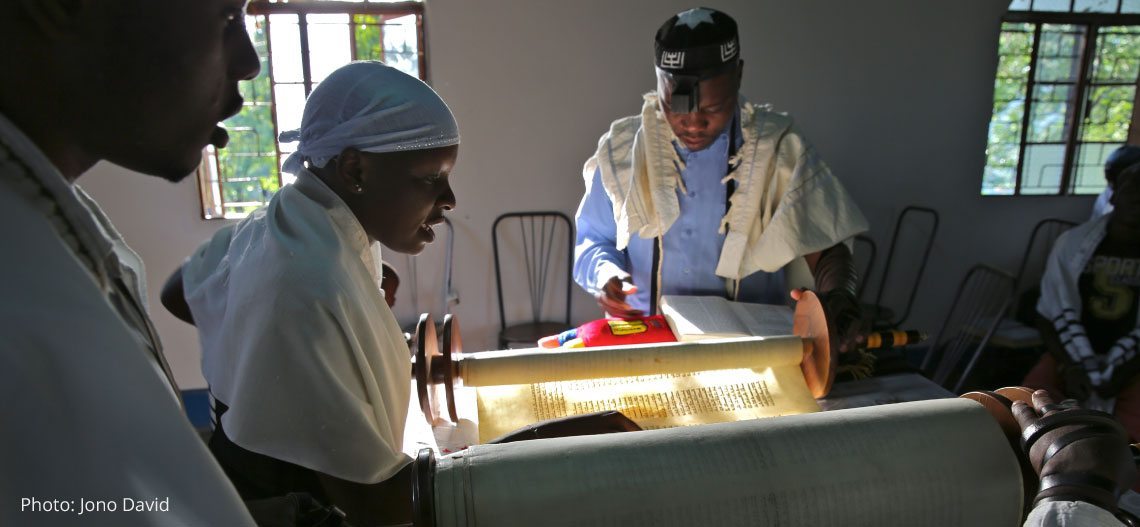 Photographer: Jono David. The daughter of Rabbi Gershom Sizomu reads from the Torah at shacharit (morning) service, Moses Synagogue. Abayudaya Jewish community. Nabugoye Village, Mbale, Uganda. September 2013