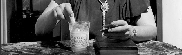 Leni Sonnenfeld lighting a memorial candle. New York, 1950s. Photo: Herbert Sonnenfeld. The Oster Visual Documentation Center, ANU – Museum of the Jewish People, Sonnenfeld collection